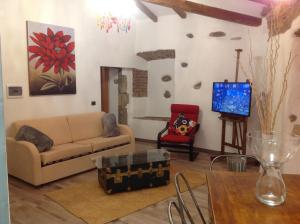 sala de estar con sofá y TV en casa vacanza serena en Palazzago