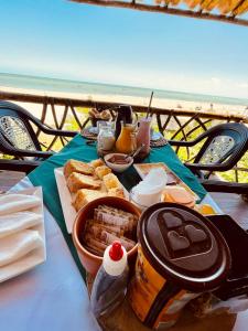 Pousada Paradise Flecheiras في ترايري: طاولة عليها طعام مطلة على المحيط
