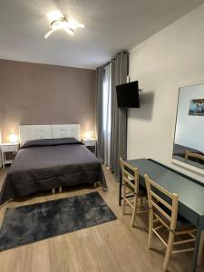 a bedroom with a bed and a table and a desk at Franciacorta Rooms in Corte Franca