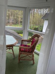 a porch with a chair and a table and windows at Ferienhaus Weniger in Bad Saarow