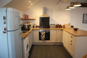 a kitchen with a refrigerator and a stove at Clock Tower Apartment in Llandrindod Wells
