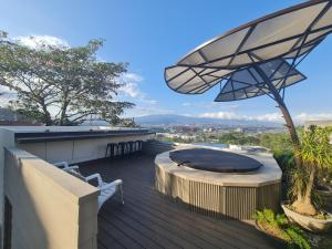 una terraza al aire libre con mesa y sombrilla en Cozy private Apartment, Mirador Escazú -Great view-, en Escazú