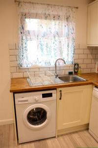 a kitchen with a sink and a washing machine at Hardwick House in Banbury