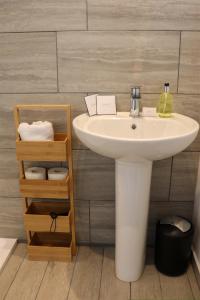 a bathroom with a sink and a shelf with towels at Hardwick House in Banbury