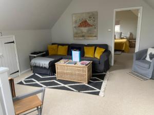 ein Wohnzimmer mit einem Sofa und einem Tisch in der Unterkunft The Nookery in Winscombe
