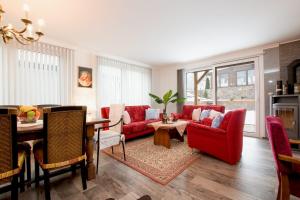 ein Wohnzimmer mit einem roten Sofa und einem Tisch in der Unterkunft Vila Residence Leo in Marienbad