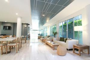a lobby with tables and chairs and a dining room at P21 Chiangmai Hotel in Chiang Mai