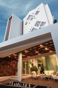 un edificio con mesas y sillas en un patio en P21 Chiangmai Hotel, en Chiang Mai