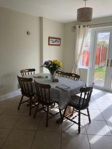 uma mesa de jantar com cadeiras e um vaso de flores em Self catering Oranmore em Oranmore