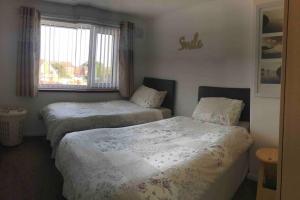 a room with two beds and a window at Diana House in Foleshill