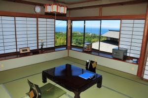 Cette chambre dispose d'une table et de fenêtres. dans l'établissement Yokohama Fujiyoshi Izuten, à Itō