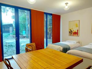 Zimmer mit 2 Betten, einem Tisch und einem Fenster in der Unterkunft Villa with private pool and garden in Tradate