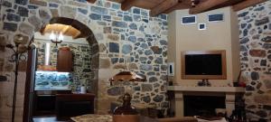 a living room with a stone wall at FILEMA HOME (stone house) in Anópolis