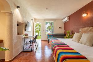 a bed with a colorful blanket on it in a room at Soy Local Cancun in Cancún