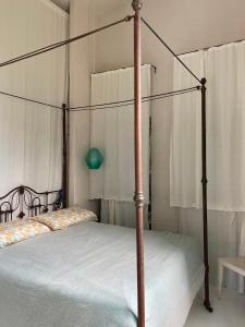1 dormitorio con cama con dosel y sábanas blancas en Capri Suite Marina Grande, en Capri