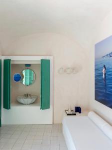 y baño con lavabo y espejo. en Capri Suite Marina Grande, en Capri