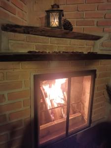 a brick fireplace with a fire in it at Casa da Lilica in Visconde De Maua