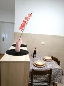 une table avec un vase de fleurs sur un comptoir dans l'établissement MB apartman, à Obrenovac