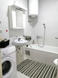 La salle de bains blanche est pourvue d'un lave-linge et d'un lavabo. dans l'établissement MB apartman, à Obrenovac