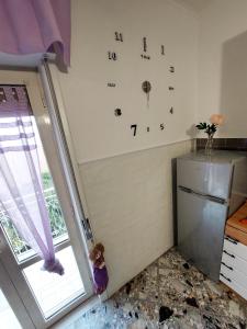 a kitchen with a clock on the wall next to a window at Casa vacanza Mamma Maria in Trecase