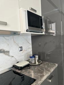 eine Küchentheke mit einem Telefon und einer Mikrowelle in der Unterkunft Psaropoula's Hidden Gem in Rhodos (Stadt)
