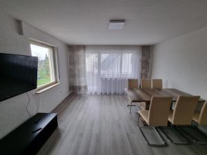 a dining room with a table and chairs and a television at Ferienwohnung Safi in Sachsenheim