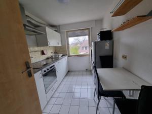 a kitchen with a refrigerator and a table and a window at Ferienwohnung Safi in Sachsenheim