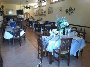 un comedor con mesas azules y sillas con flores. en Agriturismo Borgo Nuovo Sant'Agata dei Goti, en Migliara