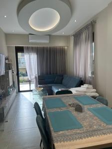 ein Wohnzimmer mit einem Tisch und einem blauen Sofa in der Unterkunft Psaropoula's Hidden Gem in Rhodos (Stadt)