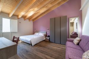 - une chambre avec un lit et un canapé dans l'établissement Villa Veronesi, à San Martino della Battaglia