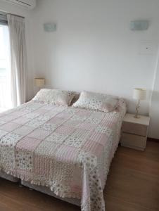 a bedroom with a bed with a pink and white blanket at Departamento Zona Puerto De Olivos in Olivos +10 photos