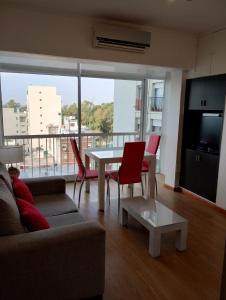 a living room with a couch and a table with chairs at Departamento Zona Puerto De Olivos in Olivos