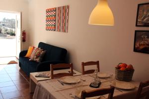 sala de estar con mesa y sofá azul en Eira Velha en Portalegre