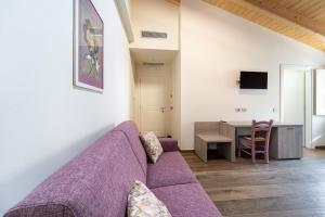 a living room with a purple couch and a table at Villa Veronesi in San Martino della Battaglia