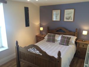 a bedroom with a bed with two night stands and two lamps at Masonic House, Alston in Alston