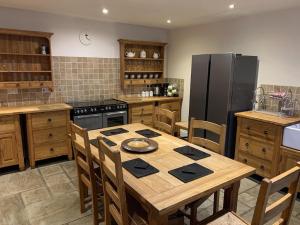 a kitchen with a wooden table and a refrigerator at Masonic House, Alston in Alston