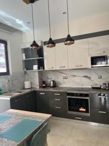 a kitchen with gray and white cabinets and a table at Psaropoula's Hidden Gem in Rhodes Town