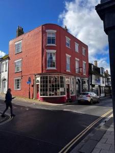 a person crossing a street in front of a red brick building at The Brontë Wing at The Apothecary Rye in Rye