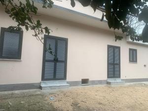 un edificio blanco con persianas negras. en Alla Casetta B&B Relax, en San Felice a Cancello