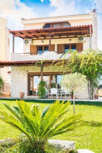a house with a green yard with a building at Villa Uliana Kassandra Greece in Afitos