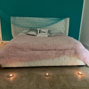 un letto con piumone rosa in camera di Alla Casetta B&B Relax a San Felice a Cancello
