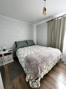 a bedroom with a bed and a white wall at Casa en Copiapó + Estacionamiento in Copiapó