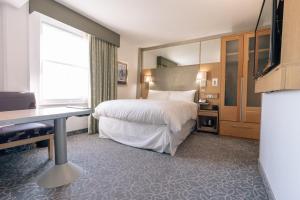 a hotel room with a bed and a desk at Club Quarters Hotel Covent Garden Holborn, London in London