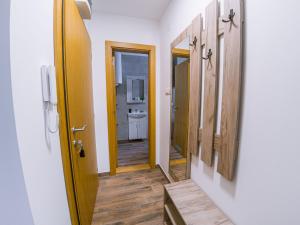 a hallway with a bathroom with a sink and a mirror at Apartman Bellini 2 in Soko Banja