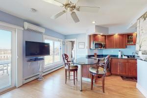 a kitchen with a table and chairs and a television at The Lookout #210 in Ogunquit