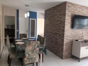 a dining room with a table and chairs and a brick wall at Apartamento Beira Praia in Fortaleza