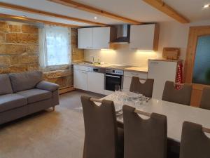 a kitchen and dining room with a table and a couch at Ferienhaus Bildhauer Thiele in Ottendorf