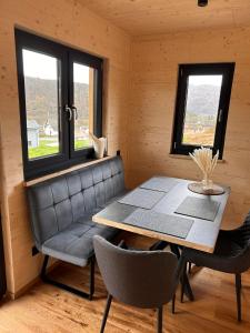 een eetkamer met een tafel, stoelen en ramen bij Ferienresort Edersee GmbH in Hemfurth-Edersee