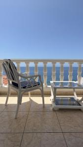 una sedia bianca e un tavolo sul balcone di 1st Line Sea View & Rooftop - Arena a Puerto de Santiago