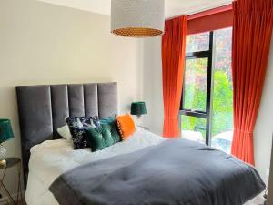 Un dormitorio con una cama grande y una ventana en Modern Luxurious Apartment w/ Patio Balcony & View, en Jordanstown